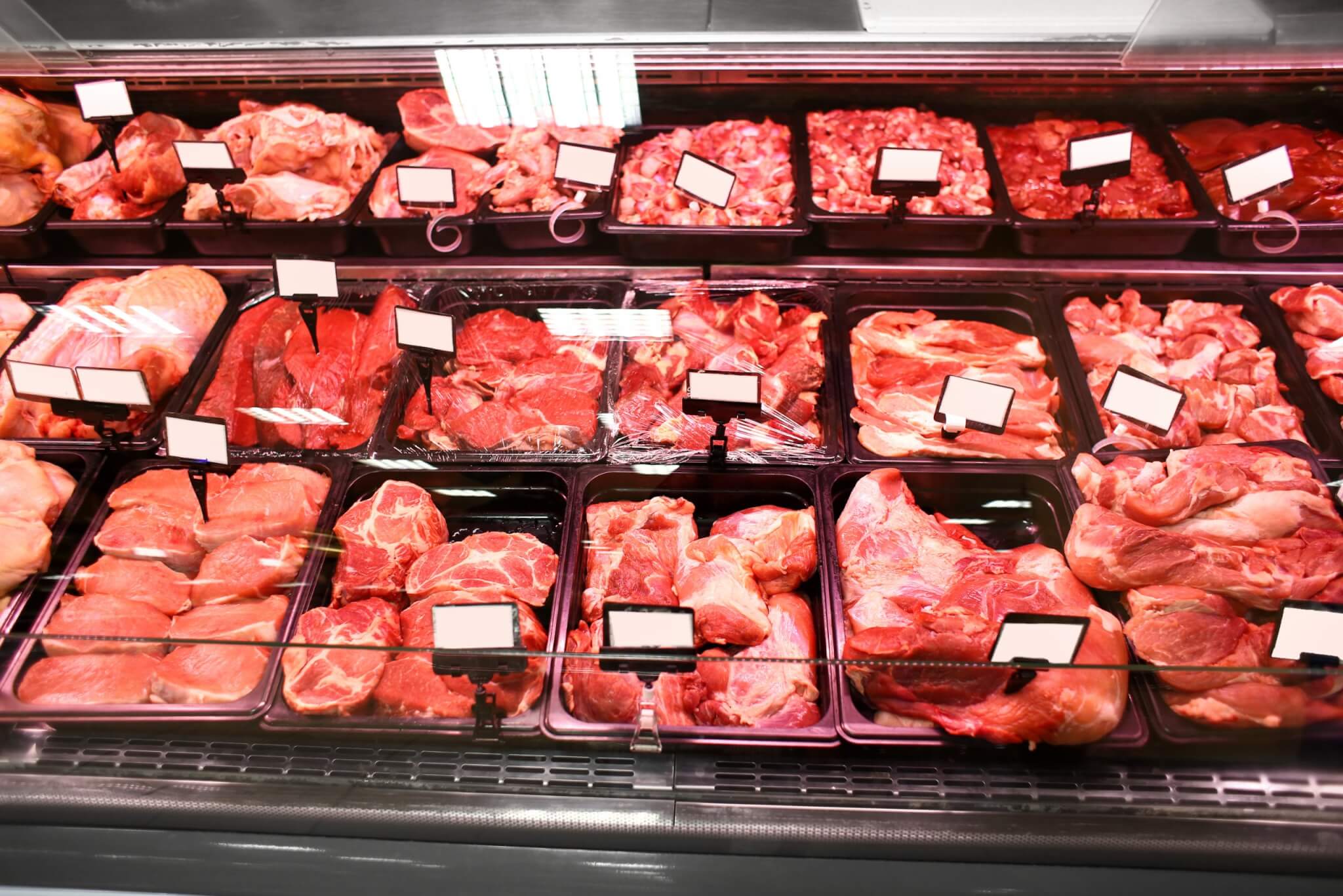Refrigerated display case with fresh meat in supermarket.