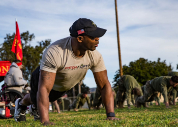Ret. U.S. Marine Corps Master Gunnery Sgt. Carnell Martin, a member of Catch a Lift (CAL), stretches with Marines with Sierra Battery, 5th Battalion, 11th Marine Regiment, 1st Marine Division during a physical training event on Marine Corps Base Camp Pendleton, California, Jan. 24, 2020. CAL is a non-profit organization that provides combat wounded veterans with personalized fitness, nutrition and wellness grants, enabling them to heal through physical fitness and mental wellbeing. The veterans with CAL curated eight different adaptive workout stations that challenged the Marines to use different muscles for common exercises. (U.S. Marine Corps photo by Cpl. Alexa M. Hernandez)