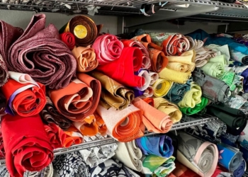 Stacks of colorful fabric rolls on a metal cabinet for Mottainai Creations, a business run by a military spouse.