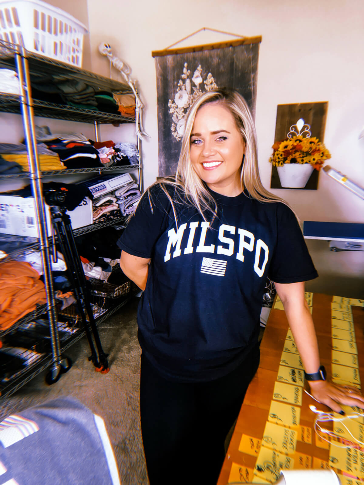 Ashlee Sullivan wearing one of the original WOMAN + WARRIOR t-shirt designs that says "MILSPO" with an American flag underneath.