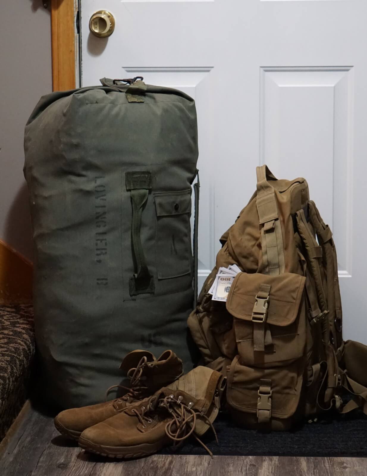Army boots and rucksacks lean against a door in preparation for a service member's deployment.