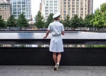 A Naval Academy Midshipman stands in front of the 9/11 Memorial parapet in New York, NY. Photo courtesy of the 9/11 Memorial & Museum, photograph by Jin S. Lee.