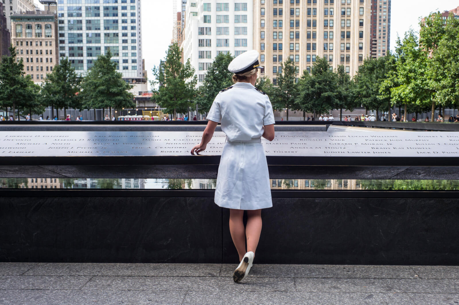 A Naval Academy Midshipman stands in front of the 9/11 Memorial parapet in New York, NY. Photo courtesy of the 9/11 Memorial & Museum, photograph by Jin S. Lee.